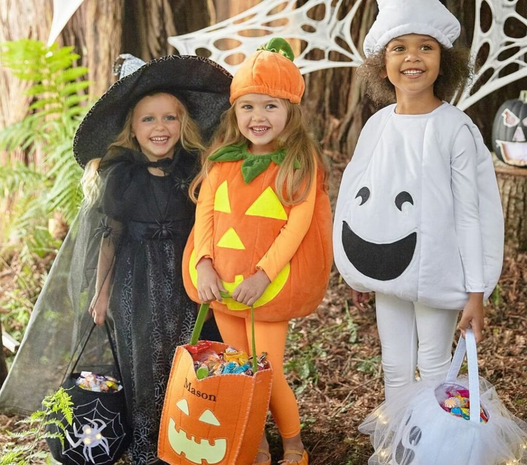 Kids wearing witch, pumpkin, and ghost costumes for halloween