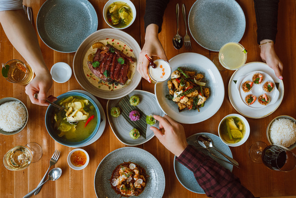 An aerial shot of a table and you can see people reaching for food and plates.
