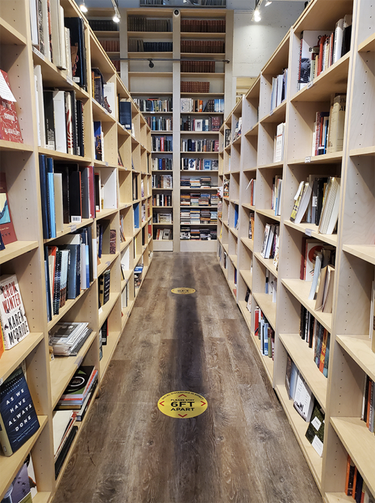 A photo taken down the middle isle of wall to wall book shelves.