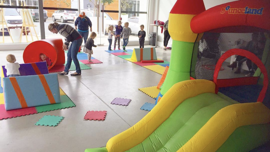 Picture of PlayAbby an indoor gym located in Abbotsford. Two moms look at several kids interacting with play structures.