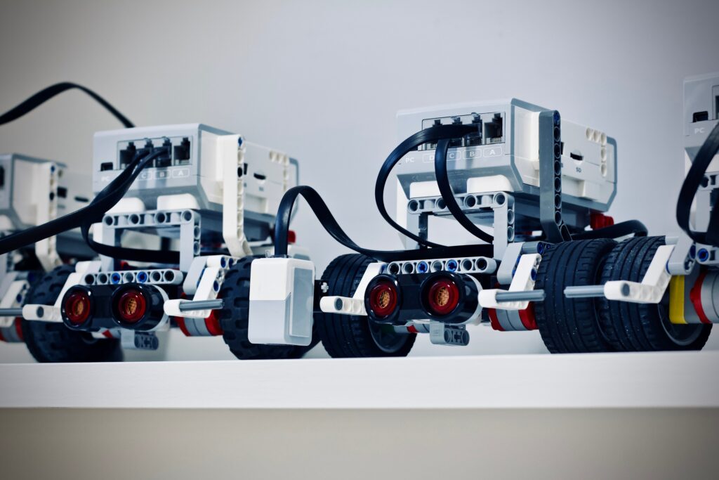 A picture of three motorized lego machines sitting on a shelf.