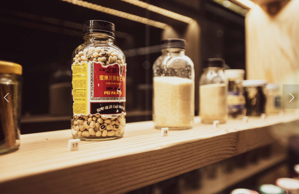 Various antique glass bottles filled with Asian food from the past.