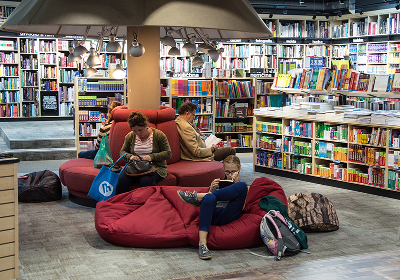 A family sits in various spots reading in a bookstore.