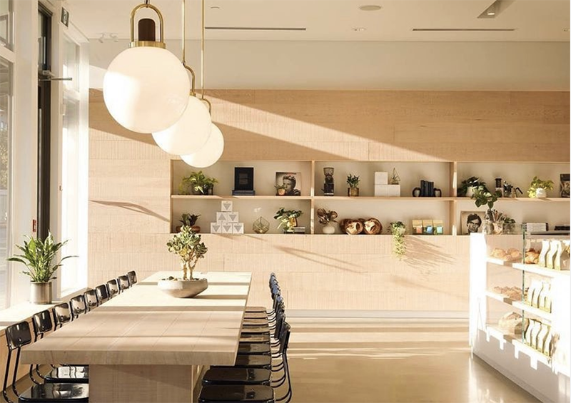 A sunny day shot of the inside of Matchsicks in Vancouver. White walls, and soft wood shelves fill an open space