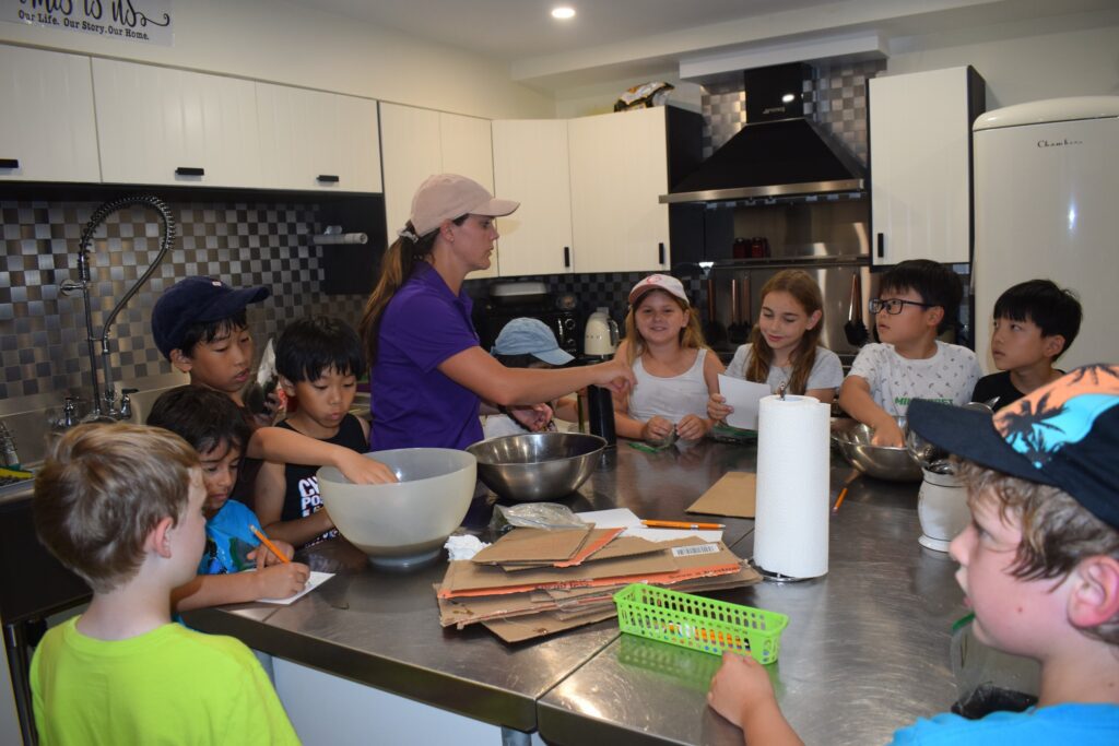 Group of kids with a Pear Tree Education Instructor learning how to cook.