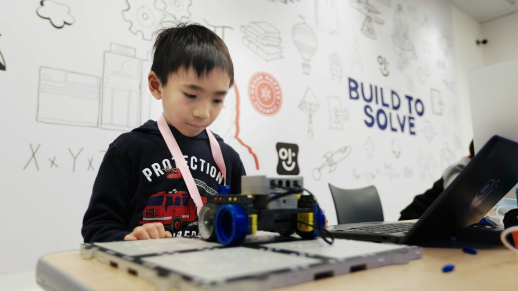 Boy at Steamoji camps building a electrical car