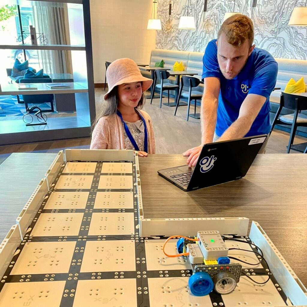 Instructor from Steamoji teaching a child about STEAM focused activities