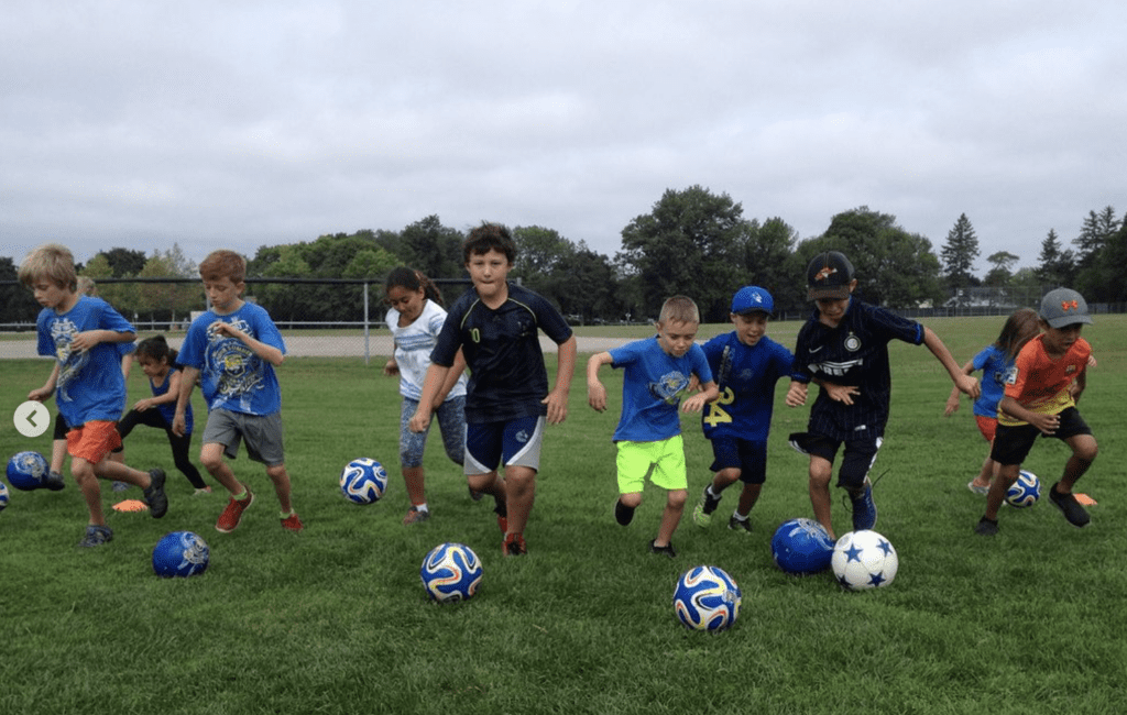 a group of kids kicking soccer balls