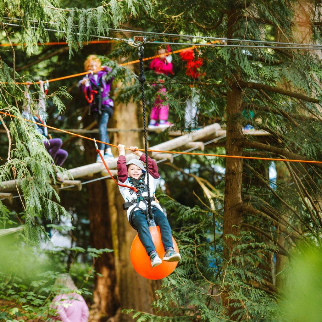 Boy on a balloon zipline through the Wildplay Parks. Other people are in line to try it out