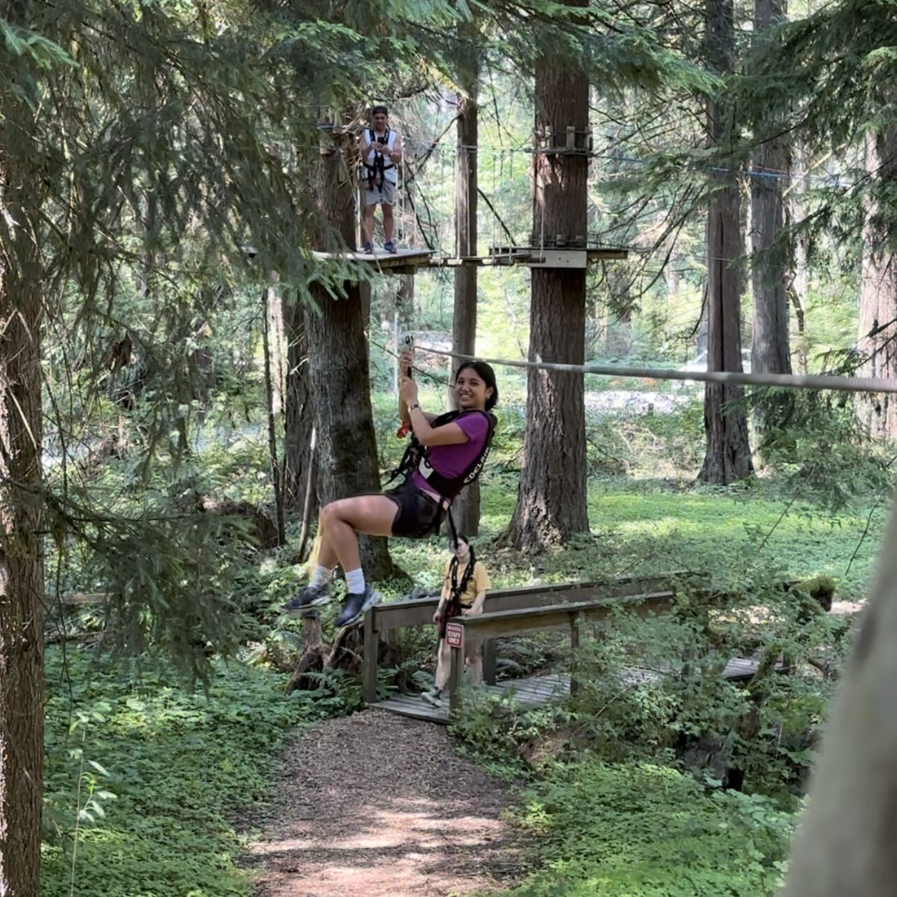 A girl ziplining from the trees