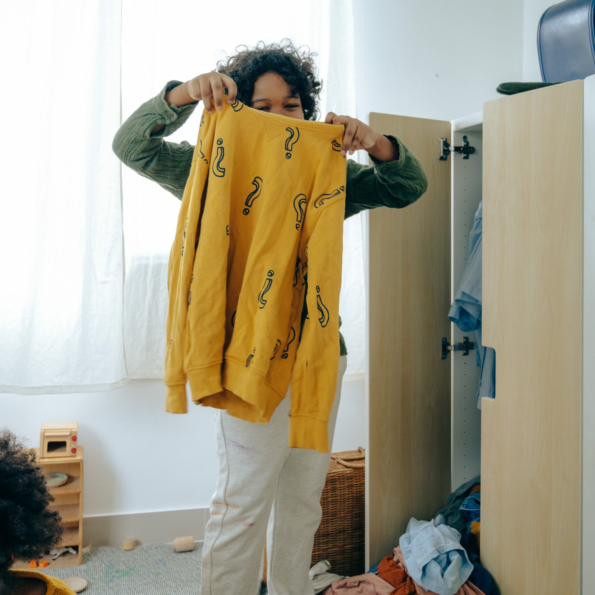 boy holding a yellow sweater getting ready for the first day of school
