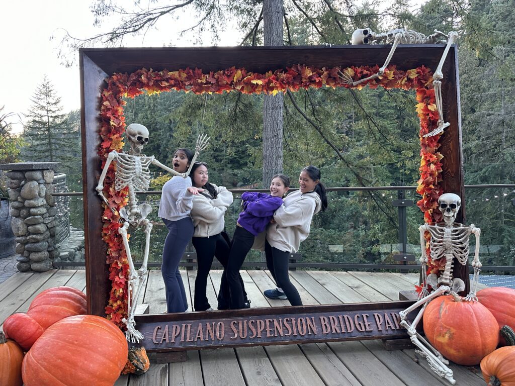 Four girls taking. a picture in a halloween display at the Capilano Suspension Bridge during a Halloween Event in Metro Vancouver