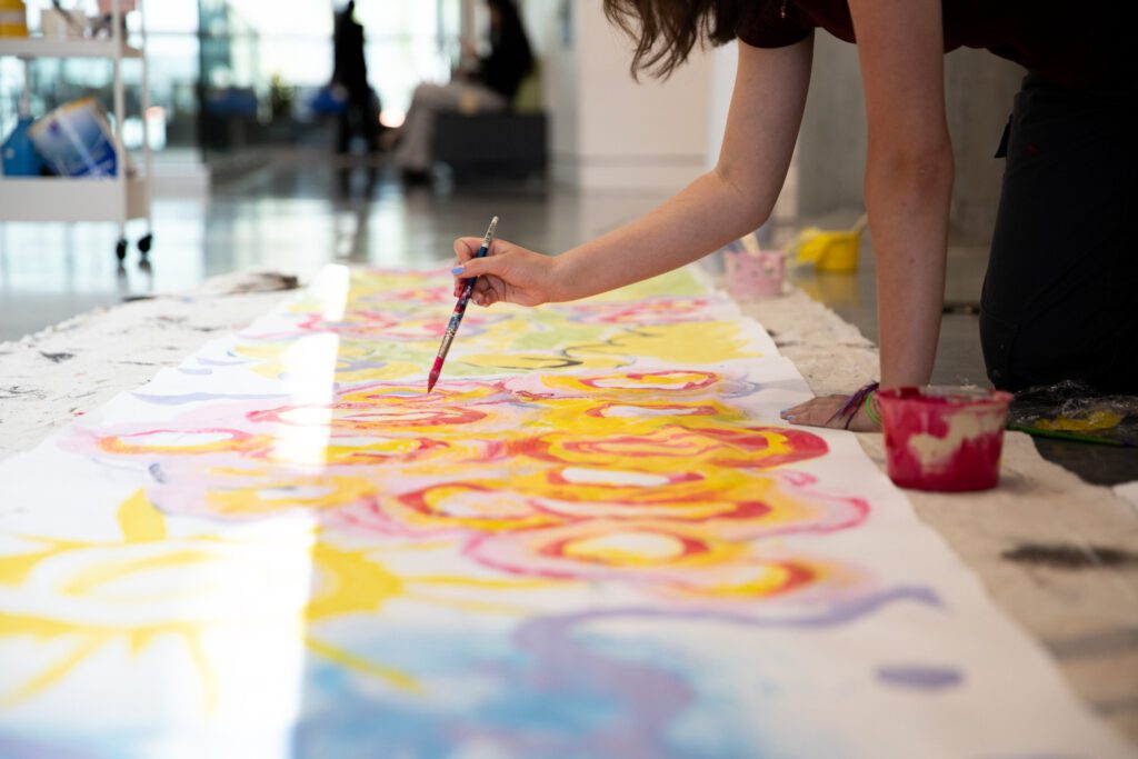 A student painting on the floor at the Emily Carr Summer Camps