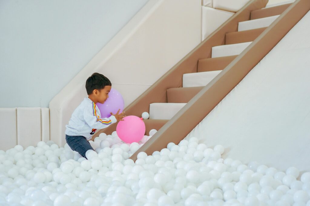 A boy playing in a ball pit for sensory play for neurodivergent children