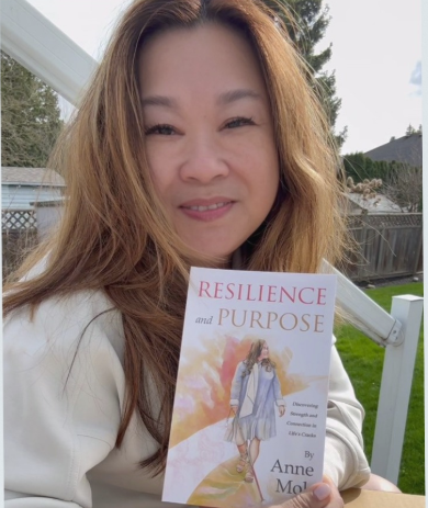 Anne Mok holding the book she wrote called Resilience and Purpose