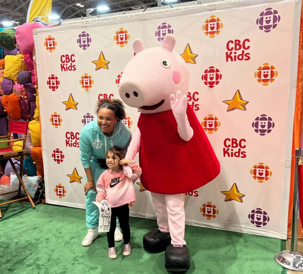 A mom and her daughter getting a picture with Peppa Pig at the Vancouver Baby Show